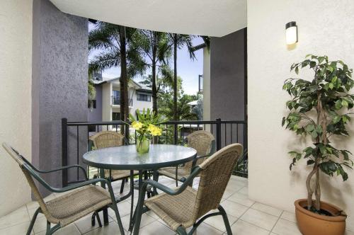 a patio with a table and chairs on a balcony at Bay Villas Resort in Port Douglas