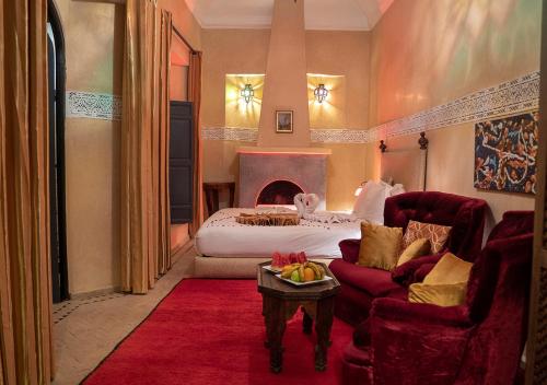 um quarto com uma cama, um sofá e uma mesa em Riad Romance em Marrakech