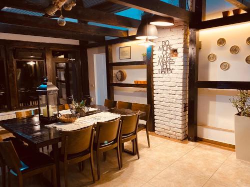 a dining room with a wooden table and chairs at Casa Pisica Noastra in Breaza