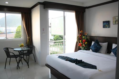 1 dormitorio con cama, mesa y ventana en Fruit Paradise Hotel, en Patong Beach