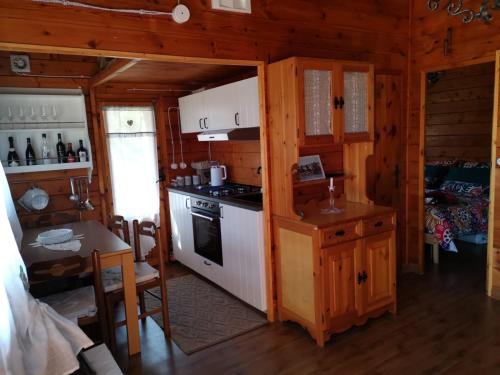 eine Küche mit einem Herd und einem Tisch in einer Hütte in der Unterkunft Etna Baite Milo in Milo