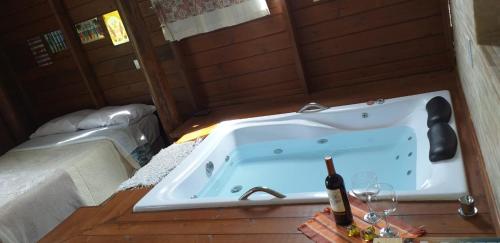 a bath tub with a bottle of wine in it at pimenta rosa guesthouse in Praia do Rosa