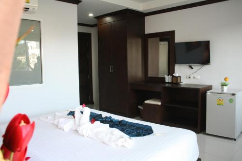 1 dormitorio con 1 cama con tocador y TV en Fruit Paradise Hotel en Patong