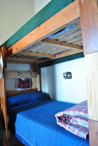 a bedroom with a bunk bed with a blue bedspread at Ruca Kiñe Hostel in Las Grutas