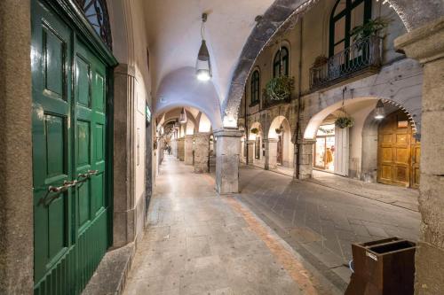 un callejón en un edificio antiguo con puertas verdes en Portico Rodriguez Cava de Tirreni, en Cava deʼ Tirreni