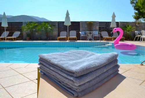 uma pilha de toalhas sentadas ao lado de uma piscina em Altis Hotel em Malia