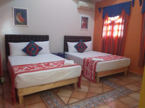 a bedroom with two beds and two lamps at Casa Oaxaca in Santa Cruz Huatulco