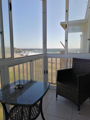 a table and chair in a room with a view of the ocean at Dpto Bordemar 1 in Las Cruces