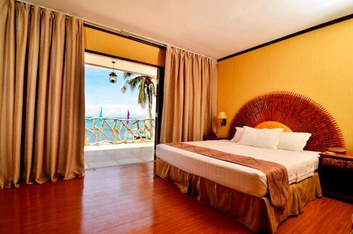 a bedroom with a bed with a view of the ocean at Malapascua Legend Water Sports and Resort in Malapascua Island