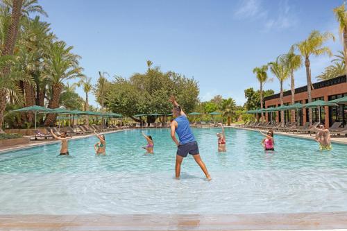 a man standing in the water at a swimming pool at Hotel Riu Tikida Garden - Adults Only - All Inclusive in Marrakech
