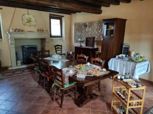 een eetkamer met een tafel en stoelen en een open haard bij B&B Santa Cristina in Montichiari