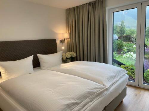 een slaapkamer met een groot wit bed en een raam bij Simon´s Ferienwohnungen in Kurort Oberwiesenthal