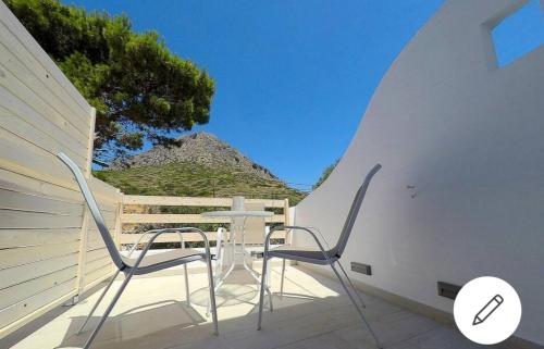 a table and chairs sitting on a patio with a wall at Afrodite Luxury Rooms in Kalymnos