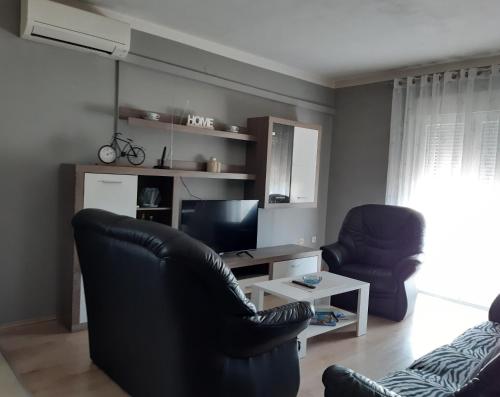 a living room with two chairs and a television at Apartment Gloria in Zadar
