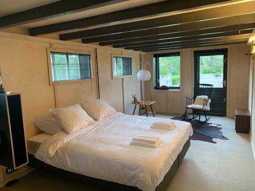 a bedroom with a large bed with white sheets at Het Lage Noorden in Marrum