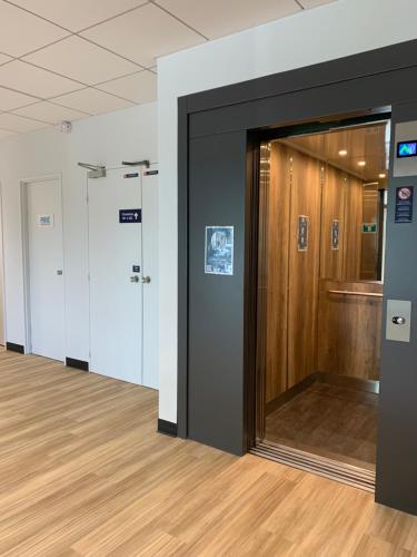 a row of doors in a room with wood floors at Kyriad Direct - Bourg les Valence in Bourg-lès-Valence
