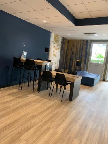 a room with tables and chairs and a couch at Kyriad Direct - Bourg les Valence in Bourg-lès-Valence