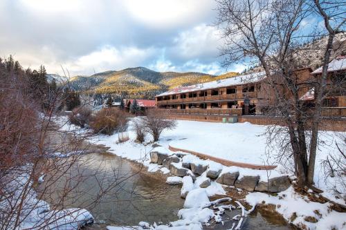 a building next to a river in the snow at WorldMark Red River in Red River