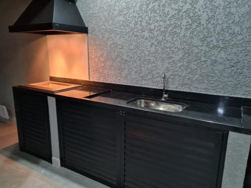 encimera con fregadero y espejo en Casa nova, conforto total e perto da praia, en Peruíbe