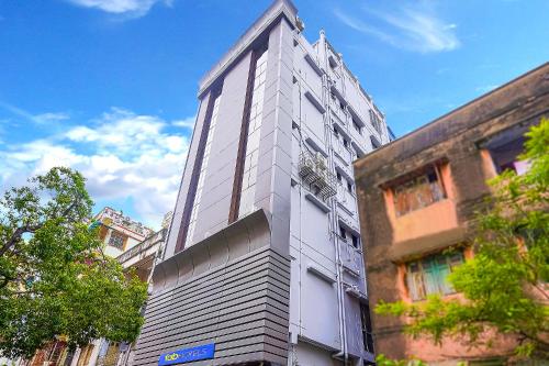 a tall white building on the side of a street at FabHotel Eros 211 - Nr Sreebhumi in Kolkata