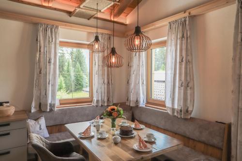 uma sala de jantar com uma mesa e duas janelas em Apartment Steger 2 em Mittersill