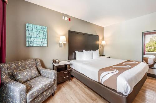a hotel room with a bed and a chair at Quality Inn Poughkeepsie in Poughkeepsie