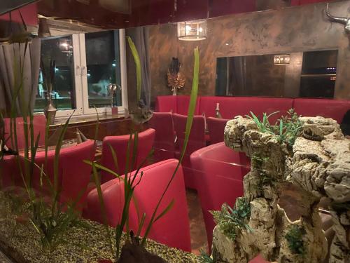 a group of red chairs in a restaurant at Hotel Boxberg in Waldbröl