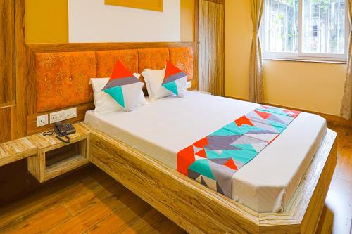 sypialnia z dużym łóżkiem z kolorowymi poduszkami w obiekcie FabExpress Quest w mieście Kolkata