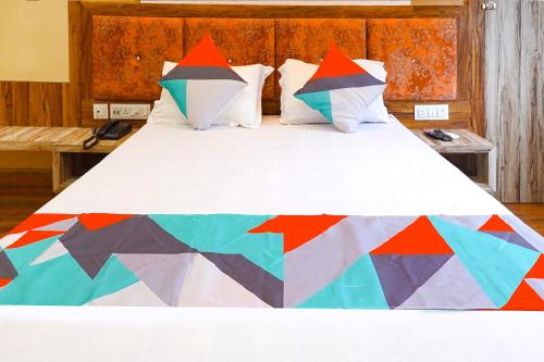 Una cama grande con un edredón colorido. en FabExpress Quest en Calcuta