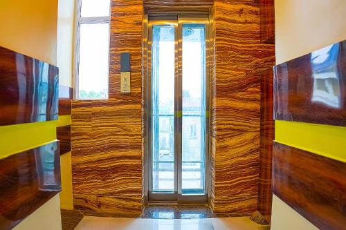 a wooden door in a room with a window at FabHotel Quest - Nr Quest Mall in Kolkata