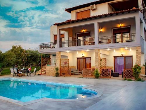 a villa with a swimming pool in front of a house at Villa Scorpion Nea Moudania Halkidiki in Nea Moudania