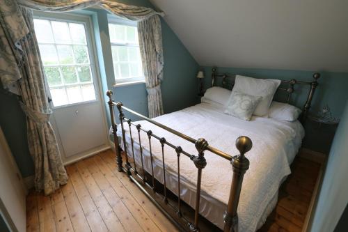 1 dormitorio con cama y ventana en Duke of Monmouth penthouse luxury apartment, Lyme Regis, 3 bedroom, Hot tub, Garden, dog friendly, en Lyme Regis