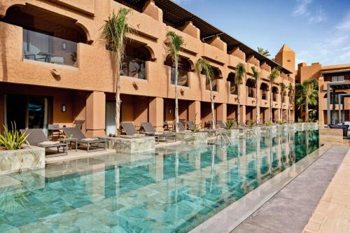 a building with a pool and a pool table in front of it at Hotel Riu Tikida Garden - All Inclusive Adults Only in Marrakesh