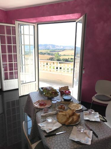 ein Tisch mit Essen darauf und ein großes Fenster in der Unterkunft OAK TREE 114 BnB in Castelfidardo