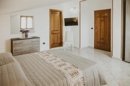 1 dormitorio grande con 1 cama grande y TV en Villa Santimone, en Éboli
