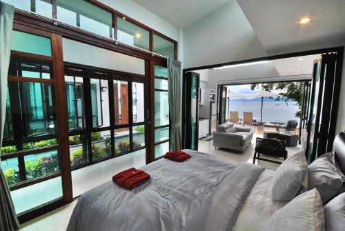 een slaapkamer met een bed met rode kussens erop bij Villa Labaron in Koh Samui 