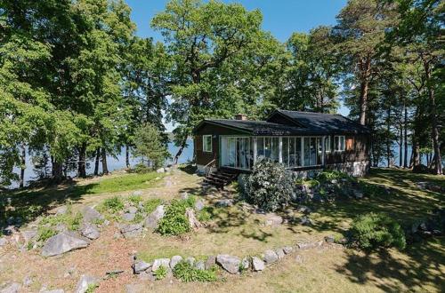 una pequeña casa en la cima de una colina con árboles en Escape to Your Very Own Private Island - Just 30 Minutes from Stockholm, en Svartsjö