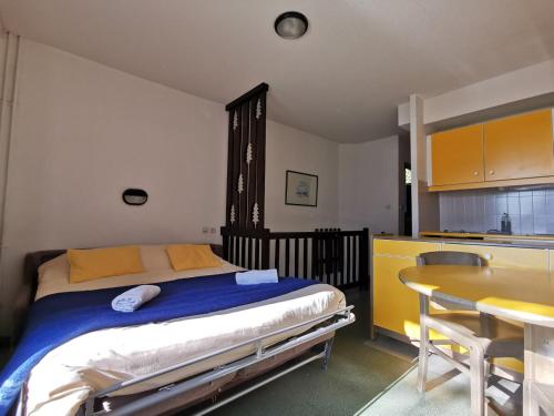 une chambre avec un lit et une table et une cuisine dans l'établissement VVF Queyras, à Ceillac