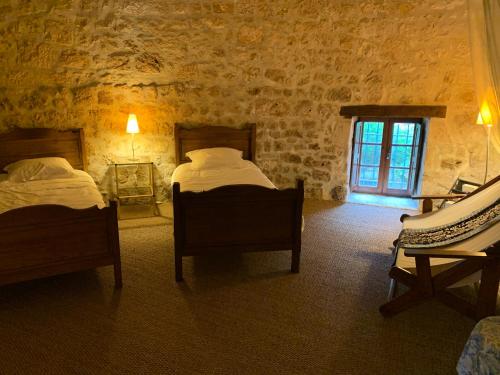 a bedroom with two beds and a window at Gite du moulin in Pranzac