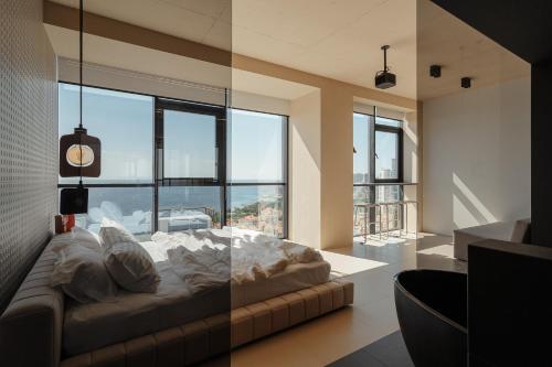 a large bed in a room with large windows at Sea and Sky Apartment in Odesa