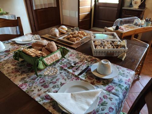 a table with a bunch of bread and pastries on it at B&B Santa Cristina in Montichiari
