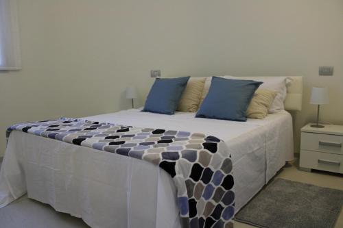 una camera da letto con un grande letto con cuscini blu di FRONTE MARE VIA DELLE DUNE a Baia Verde