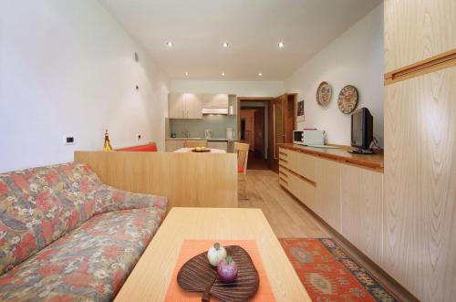 a living room with a couch and a table at Appartamenti Pastüres in Colfosco