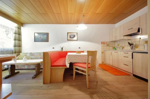 a kitchen with a table and a dining room at Appartamenti Pastüres in Colfosco
