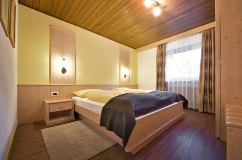 a bedroom with a large bed and a window at Appartamenti Pastüres in Colfosco