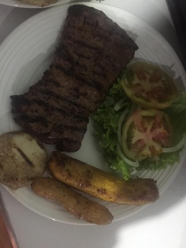a plate of food with meat and vegetables on it at CABAÑA LOS NOGALES in San Agustín
