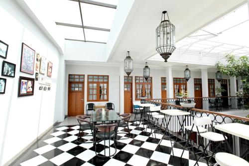 a restaurant with a black and white checkered floor at de' Halimun Guest House in Bandung