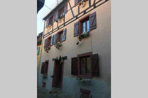 a building with a bunch of windows on it at La Maison du Rempart in Eguisheim