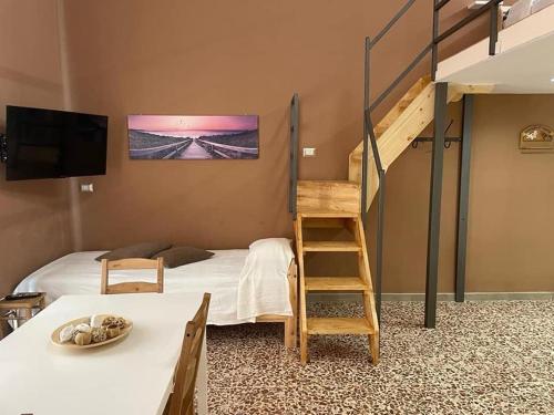 een slaapkamer met een stapelbed met een ladder en een bed met een tafel bij I VACANZIERI in Avola