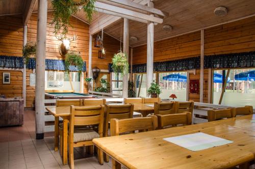 a restaurant with wooden walls and tables and chairs at Ahvenlampi Camping in Saarijärvi